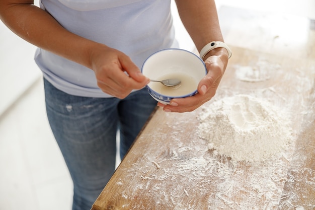 Foto la bella donna sta cucinando piatti deliziosi nella sua cucina di casa