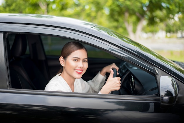 美しい女性は彼女の車を運転しています。