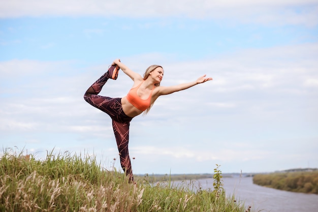 Beautiful woman is practicing yoga outdoors.