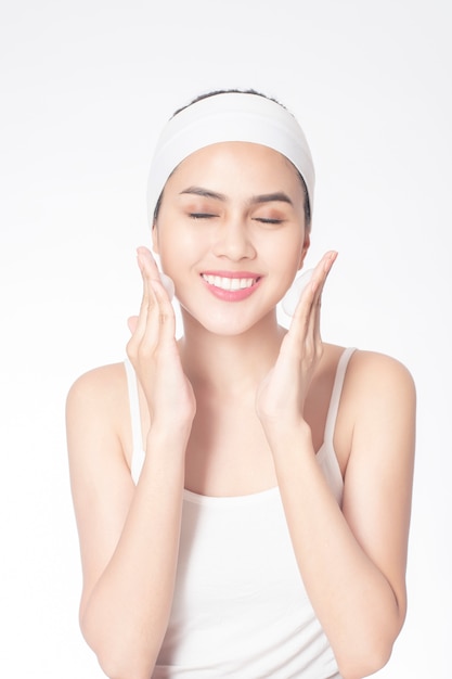 Beautiful woman is washing her face on white background 