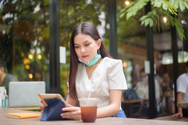 La bella donna sta indossando la maschera nella caffetteria