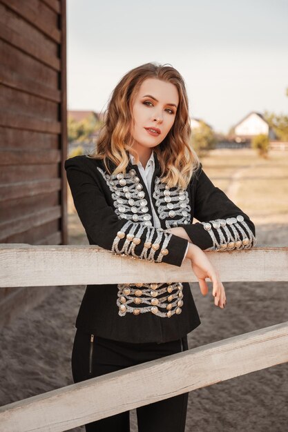 beautiful woman in a jockey costume standing on the ranch