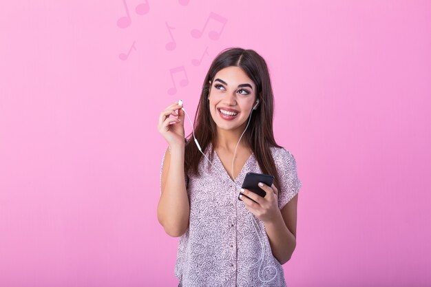 Photo beautiful woman joyful listening to music with head phones on mobile phone.
