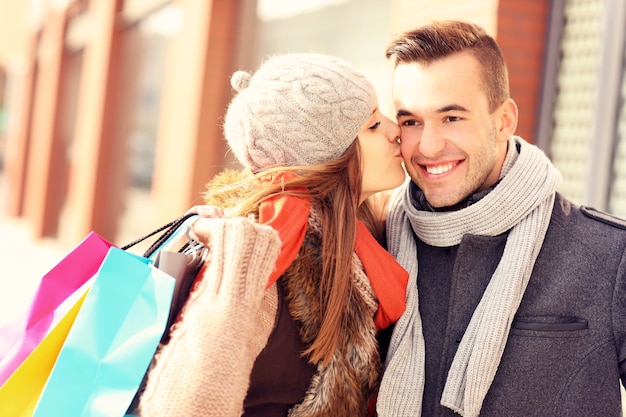 a beautiful woman kissing a man while shopping