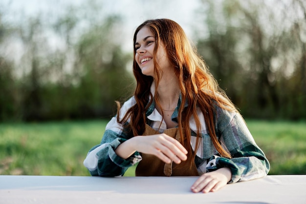 A beautiful woman laughs with a toothy smile and enjoys lounging in a green park on a summer evening in the setting sunlight The concept of a healthy lifestyle and the bati of selfcare