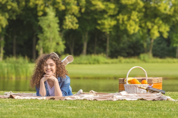 The beautiful woman lay on the grass near a river