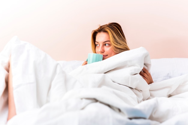 Bella donna sdraiata a letto e guardando lontano