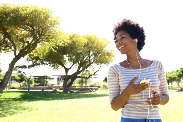 Beautiful woman listening to music on smart phone outside