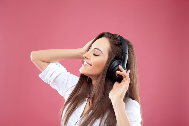 Beautiful woman listening to music using wireless headphones