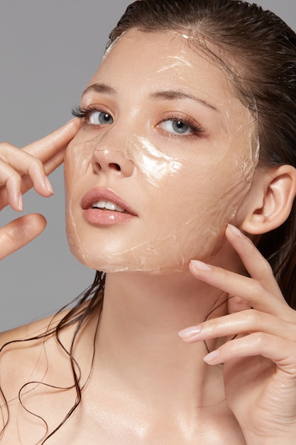 Beautiful woman looking to the camera with transperent mask on her face