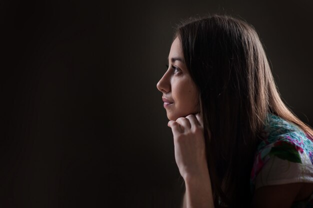 Beautiful woman looking into the distance on dark