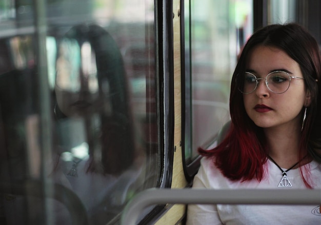 美しい女性が電車の窓から眺めている