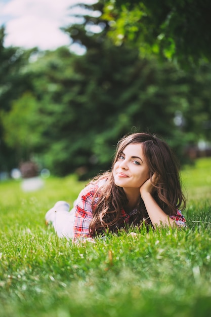 Beautiful woman lying on green grass