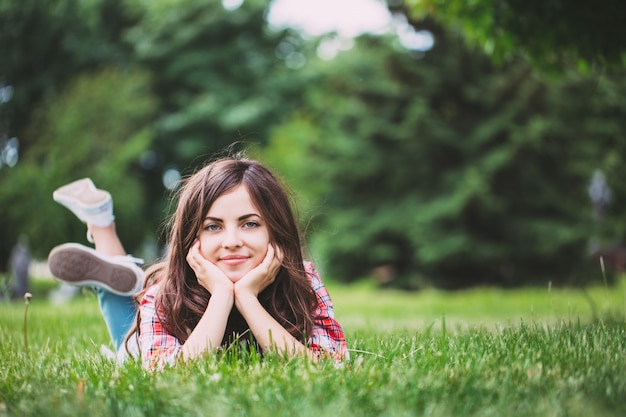 Beautiful woman lying on green grass