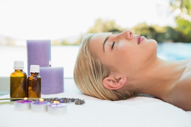 Beautiful woman lying on massage table at spa center