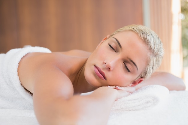 Beautiful woman lying on massage table at spa center