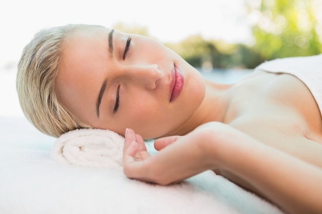Foto bella donna sdraiata sul lettino da massaggio al centro benessere