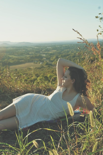 写真 空の向こうの植物の上に横たわっている美しい女性