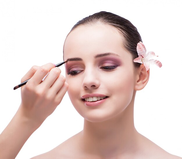 Beautiful woman during make-up cosmetics session isolated on whi