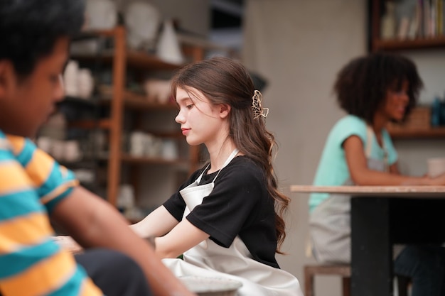 Beautiful woman making ceramic pottery on wheel hands closeup\
woman in freelance business hobby