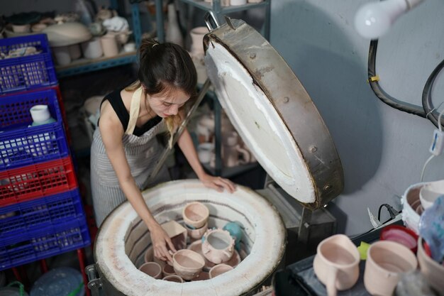 Beautiful woman making ceramic pottery on wheel hands closeup woman in freelance business hobby