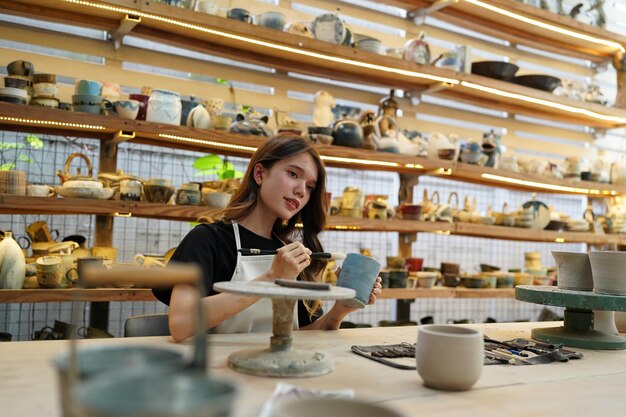 Beautiful woman making ceramic pottery on wheel hands closeup woman in freelance business hobby