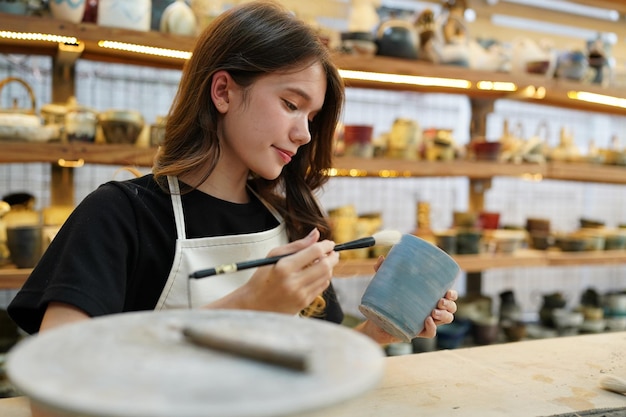 Beautiful woman making ceramic pottery on wheel hands closeup woman in freelance business hobby