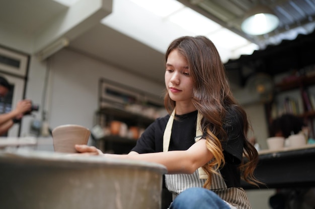 Beautiful woman making ceramic pottery on wheel hands closeup woman in freelance business hobby