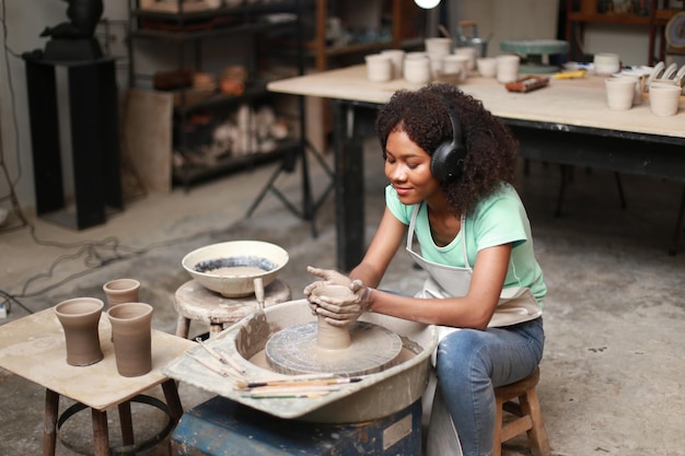 Beautiful woman making ceramic pottery on wheel hands closeup woman in freelance business hobby