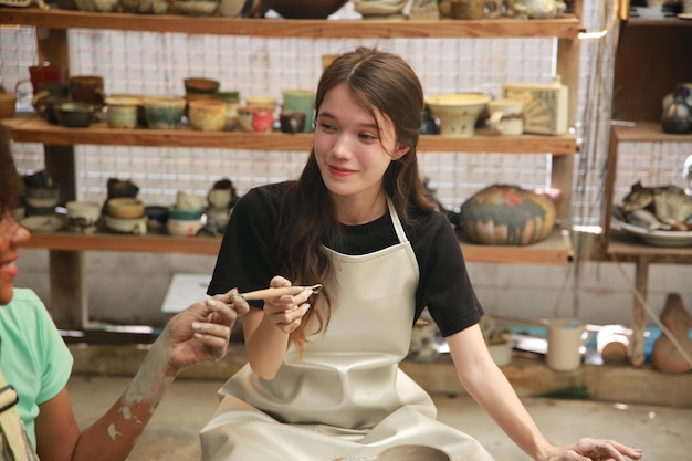 Beautiful woman making ceramic pottery on wheel hands closeup woman in freelance business hobby