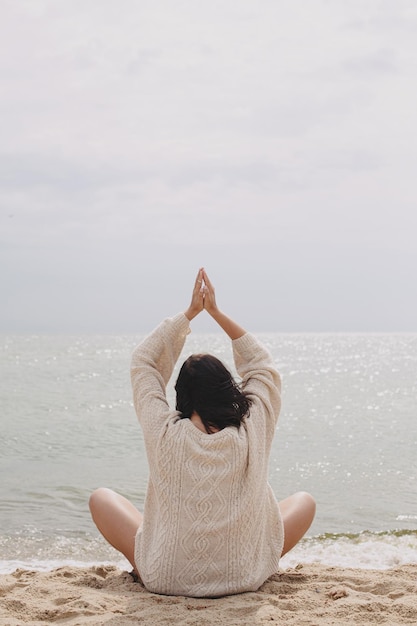 Photo beautiful woman meditating on sandy beach at sea practising yoga meditation and mindfulness