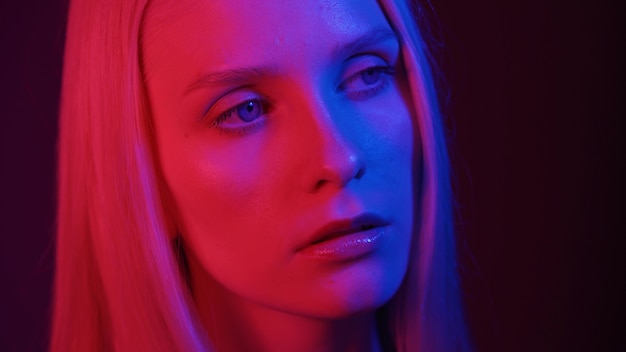 Модель красивая женщина с голубыми глазами, позирует в неоновом свете крупным планом. Концепция фотографии моды. 4K UHD