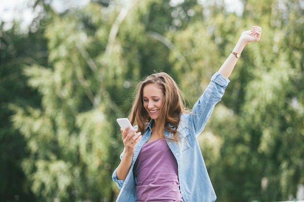 Beautiful woman model with mobile phone smartphone outside