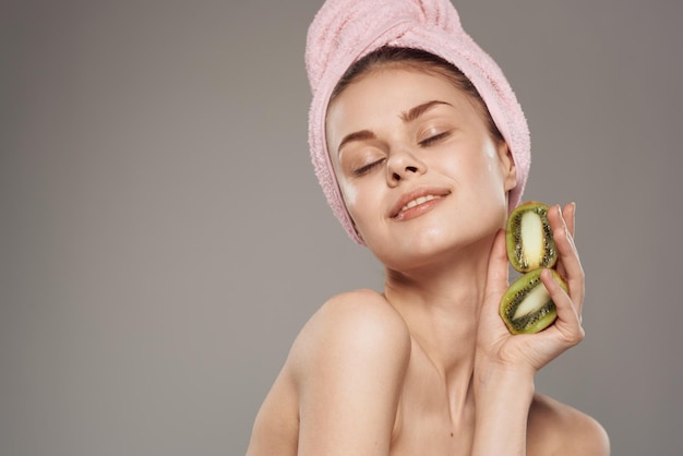 Beautiful woman naked shoulders kiwi in the hands of spa treatments