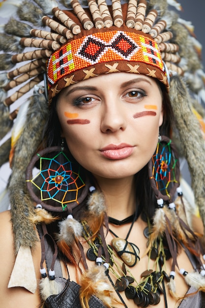 Foto bella donna in costume nativo americano con piume