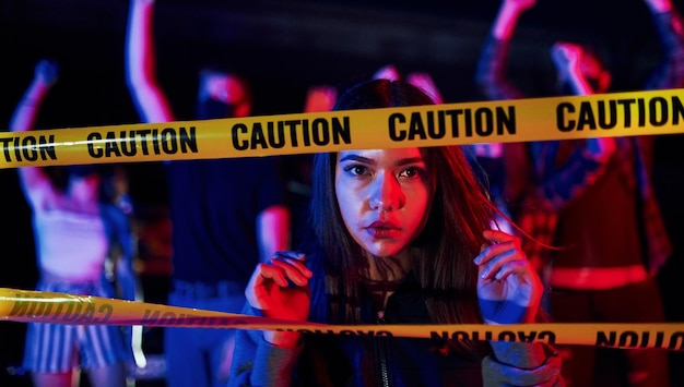 Beautiful woman near police border line group of protesting\
young people that standing together activist for human rights or\
against government