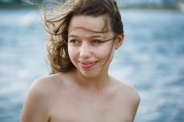 Beautiful woman near sea, wind in the hair