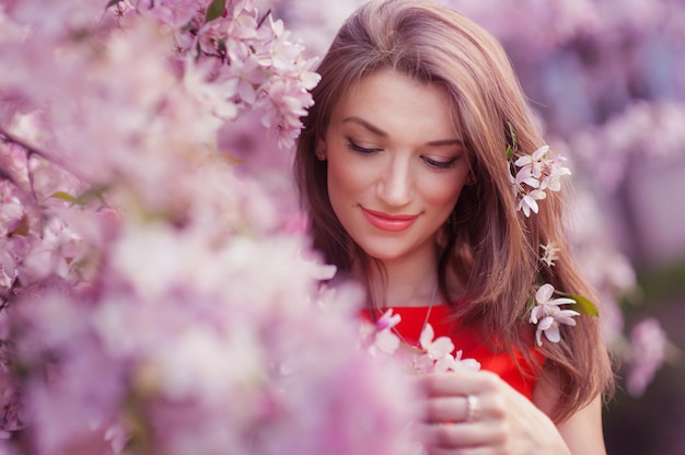 開花春の木の近くの美しい女性