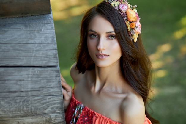 Beautiful woman in an orange dress with a wreath