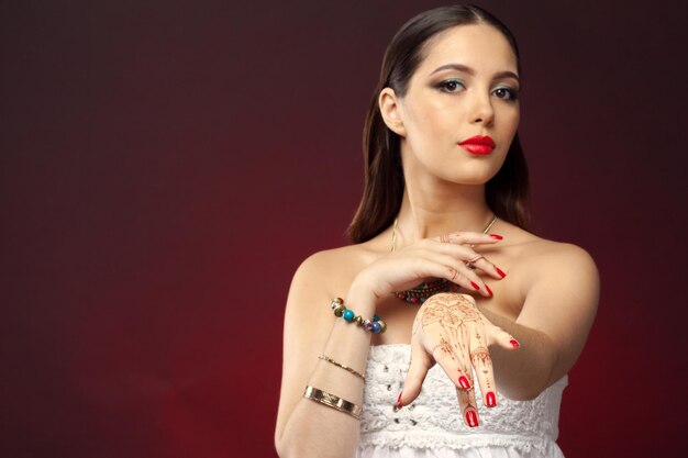 Beautiful woman in oriental style with mehendi on dark background