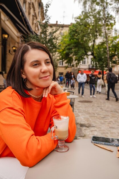 Beautiful woman at outside cafe drinking coffee copy space