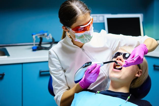 Beautiful woman patient having dental treatment at dentist's office Woman visiting her dentist