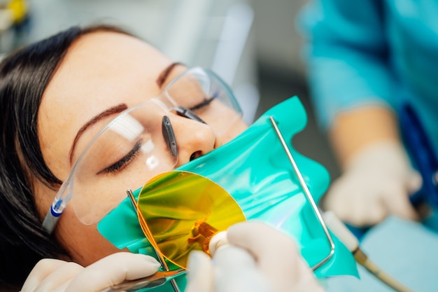 Beautiful woman patient having dental treatment at dentist's office.