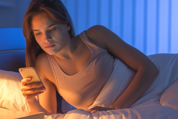 Il telefono della bella donna in camera da letto. notte