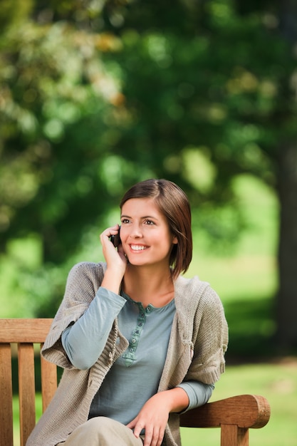 Beautiful woman phoning on the bench