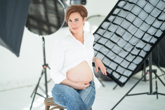 赤ちゃんを期待して、写真スタジオで美しい女性