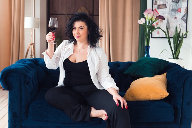 Foto bella donna plus size rilassarsi con un bicchiere di vino