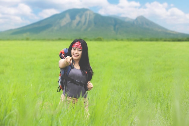 Beautiful woman pointing at you in the meadow