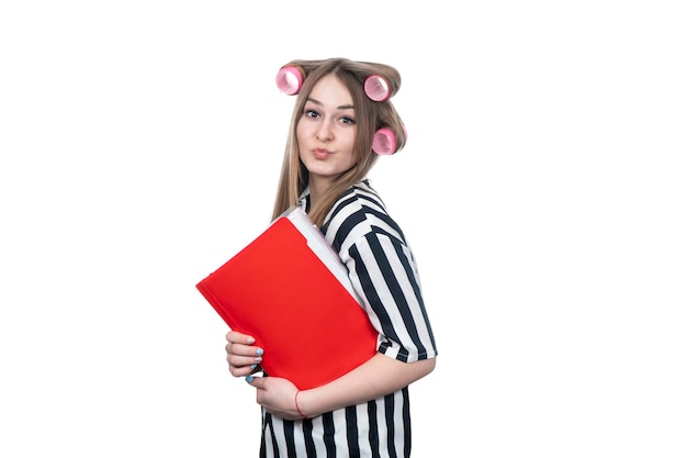 beautiful woman in polka-dot shirt with hair curlers on her head and a folder in her hand isolated on white background