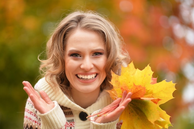 Beautiful woman portrait posing outdoors in autumn with leaves